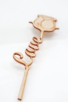 Elegant wooden stick with rose design spelling 'Love' in a script style.